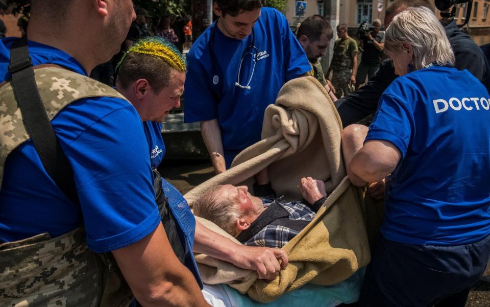 Volunteers evacuate a local resident from a flooded area after the Nova Kakhovka dam breached, amid Russia's attack on Ukraine, in Kherson - Vladyslav Musiienko/REUTERS