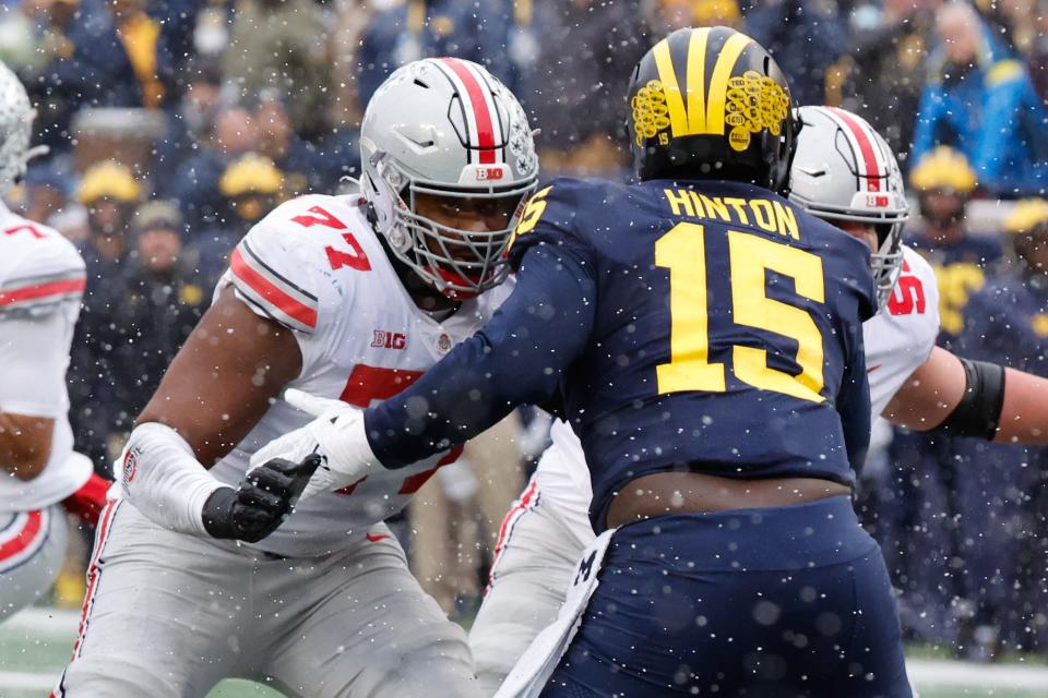 Ohio State Buckeyes offensive lineman Paris Johnson Jr. (77) blocks Michigan Wolverines defensive lineman Christopher Hinton (15) at Michigan Stadium in Ann Arbor, Michigan, on Nov. 27, 2021.