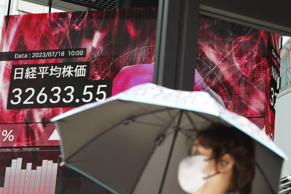 A person walks in front of an electronic stock board showing Japan's Nikkei index at a securities firm Tuesday, July 18, 2023, in Tokyo. Shares were mostly lower Tuesday in Asia as optimism over a Wall Street rally was countered by worries about the Chinese economy.(AP Photo/Eugene Hoshiko)