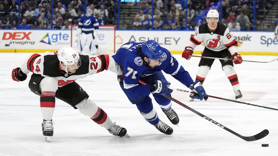 Tampa Bay Lightning center Anthony Cirelli (71) gets tripped by New Jersey Devils defenseman Colin Miller (24) during the second period of an NHL hockey game Saturday, Jan. 27, 2024, in Tampa, Fla. (AP Photo/Chris O'Meara)