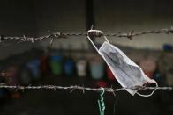 Una máscara se seca colgada en la valla de la vivienda en la que viven los trabajadores de la fábrica. (Reuters/Damir Sagolj).