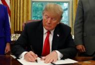 U.S. President Donald Trump signs an executive order on immigration policy in the Oval Office of the White House in Washington, U.S., June 20, 2018. REUTERS/Leah Millis