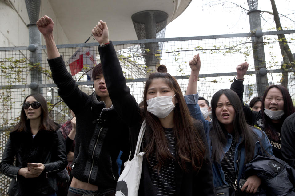 Demonstrators from the Asian community protest outside Paris' 19th district's police station, Tuesday March 28, 2017. Violent clashes in Paris between baton-wielding police and protesters outraged at the police killing of a Chinese man in his home have seen three police officers injured and 35 protesters arrested, authorities said Tuesday. (AP Photo/Michel Euler)