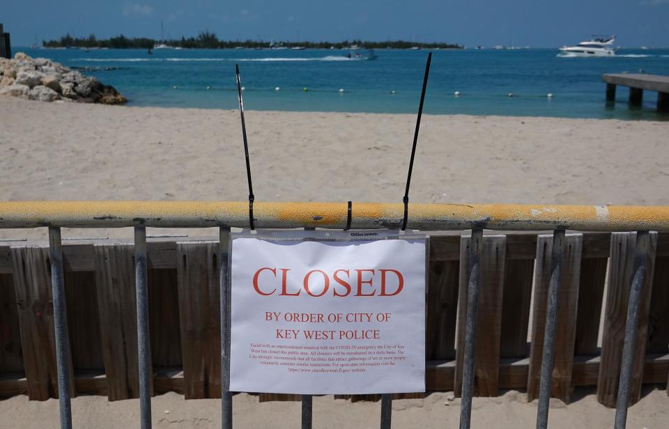A sign indicates that a beach is closed as the city government takes steps to fight the coronavirus outbreak on March 25, 2020 in Key West, Florida.