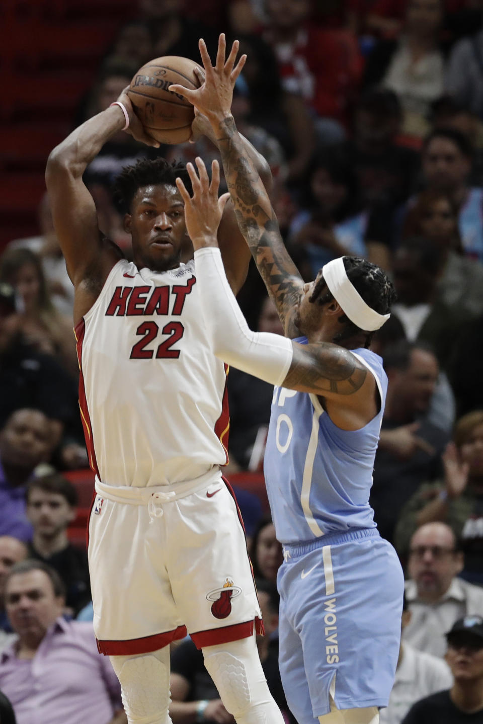 Miami Heat forward Jimmy Butler (22) passes past Minnesota Timberwolves guard D'Angelo Russell (0) during the first half of an NBA basketball game, Wednesday, Feb. 26, 2020, in Miami. (AP Photo/Wilfredo Lee)