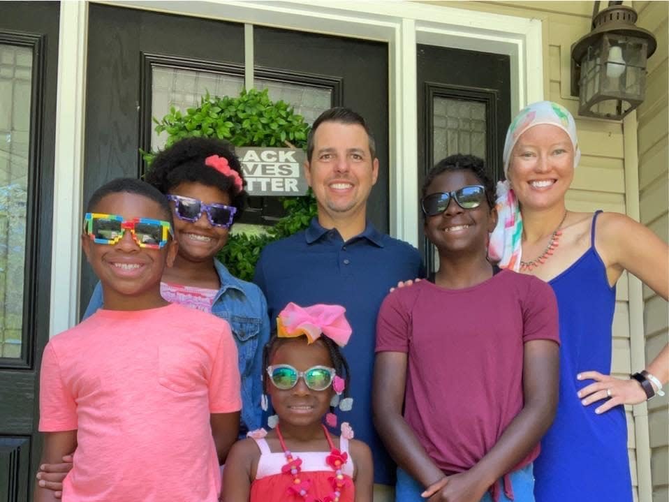 Rachel Garlinghouse with her husband and four kids standing on the porch of their house.