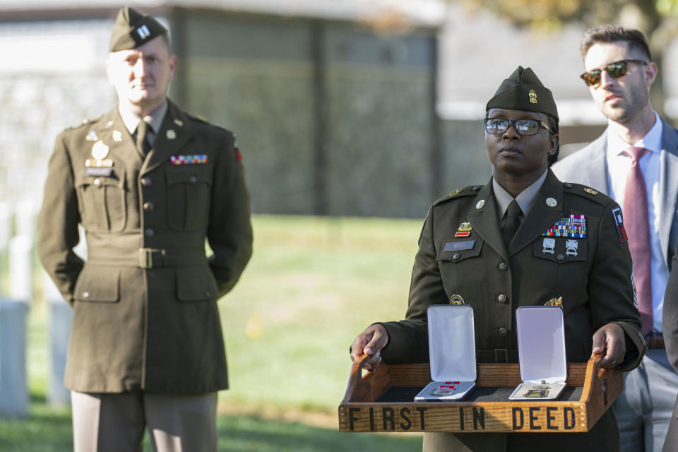 A soldier, right, holds the Bronze Star and Combat Medic Badge to be posthumously presented to Cpl. Waverly B. Woodson Jr. during a ceremony at Arlington National Cemetery on Tuesday, Oct. 11, 2023 in Arlington, Va. During the D-Day invasion, Woodson's landing craft took heavy fire and he was wounded before even getting to the beach, but for the next 30 hours he treated 200 wounded men while under intense small arms and artillery fire before collapsing from his injuries and blood loss, according to accounts of his service. (AP Photo/Kevin Wolf)