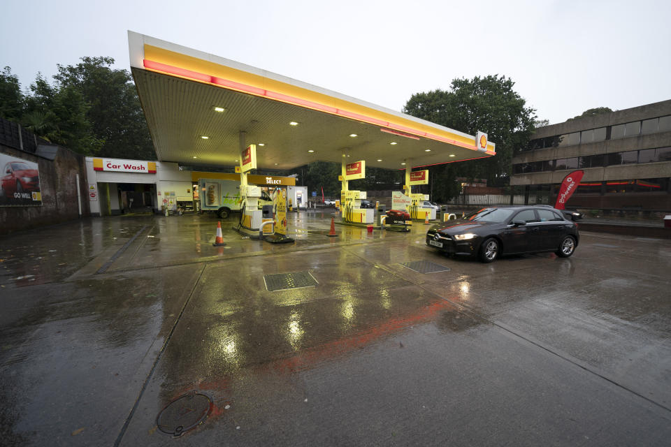 A car drives through the forecourt of a petrol station in Manchester which has run out of fuel after an outbreak of panic buying in the UK, Monday, Sept. 27, 2021. British Prime Minister Boris Johnson is said to be considering whether to call in the army to deliver fuel to petrol stations as pumps ran dry after days of panic buying. (AP Photo/Jon Super)