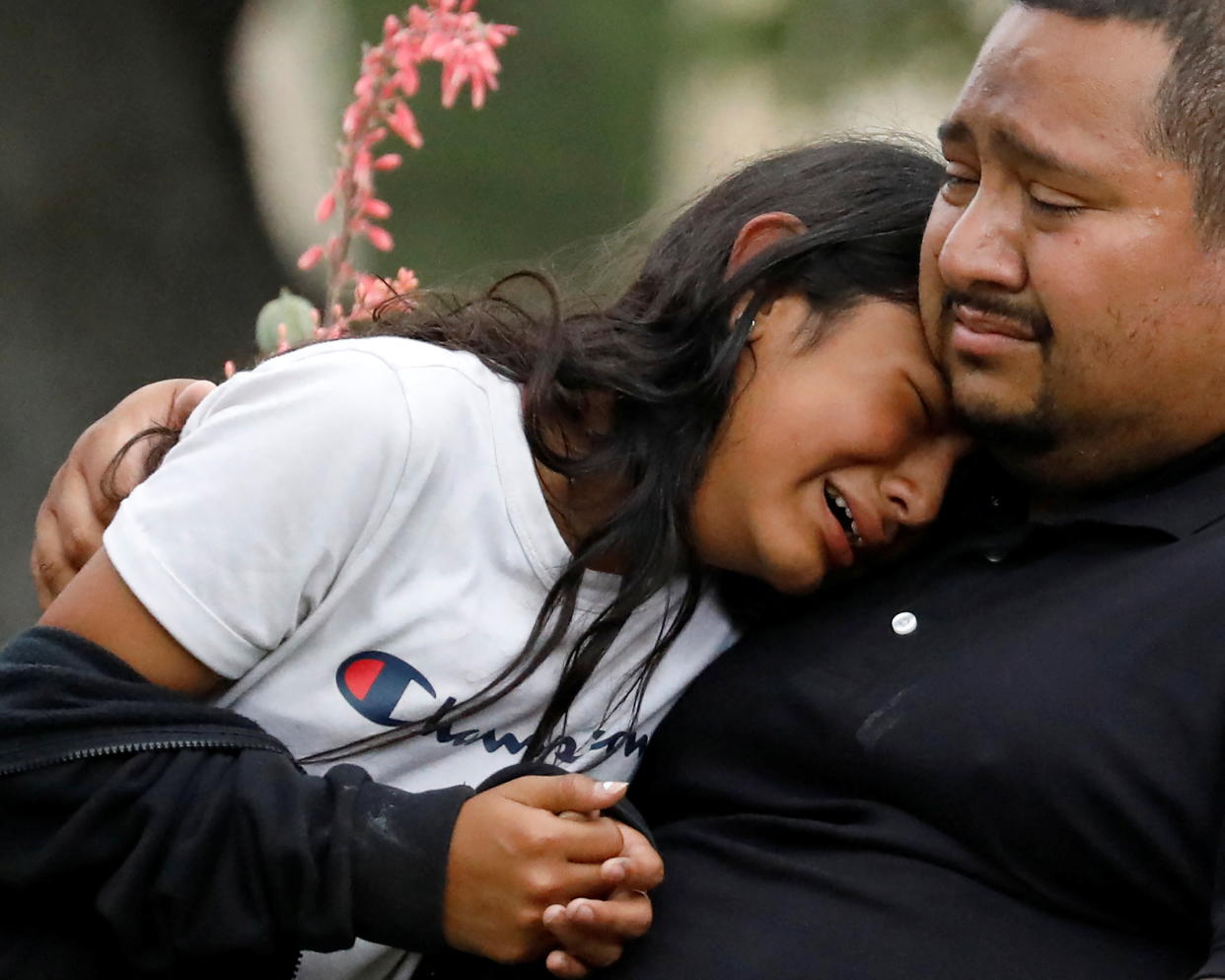 Two people embrace each other, both in tears.