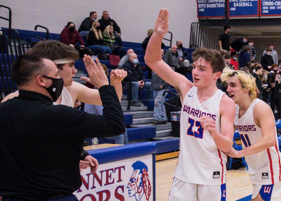 Winnacunnet junior Josh Schaake (23) is congratulated by head coach Jay McKenna after hitting a game-winning, buzzer-beating 3-pointer on Friday against Alvirne.