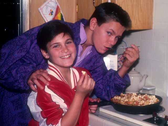 <p>Dianna Whitley/Getty </p> Joaquin Phoenix with late brother River Phoenix cooking at their home in Los Angeles, California, circa 1985.