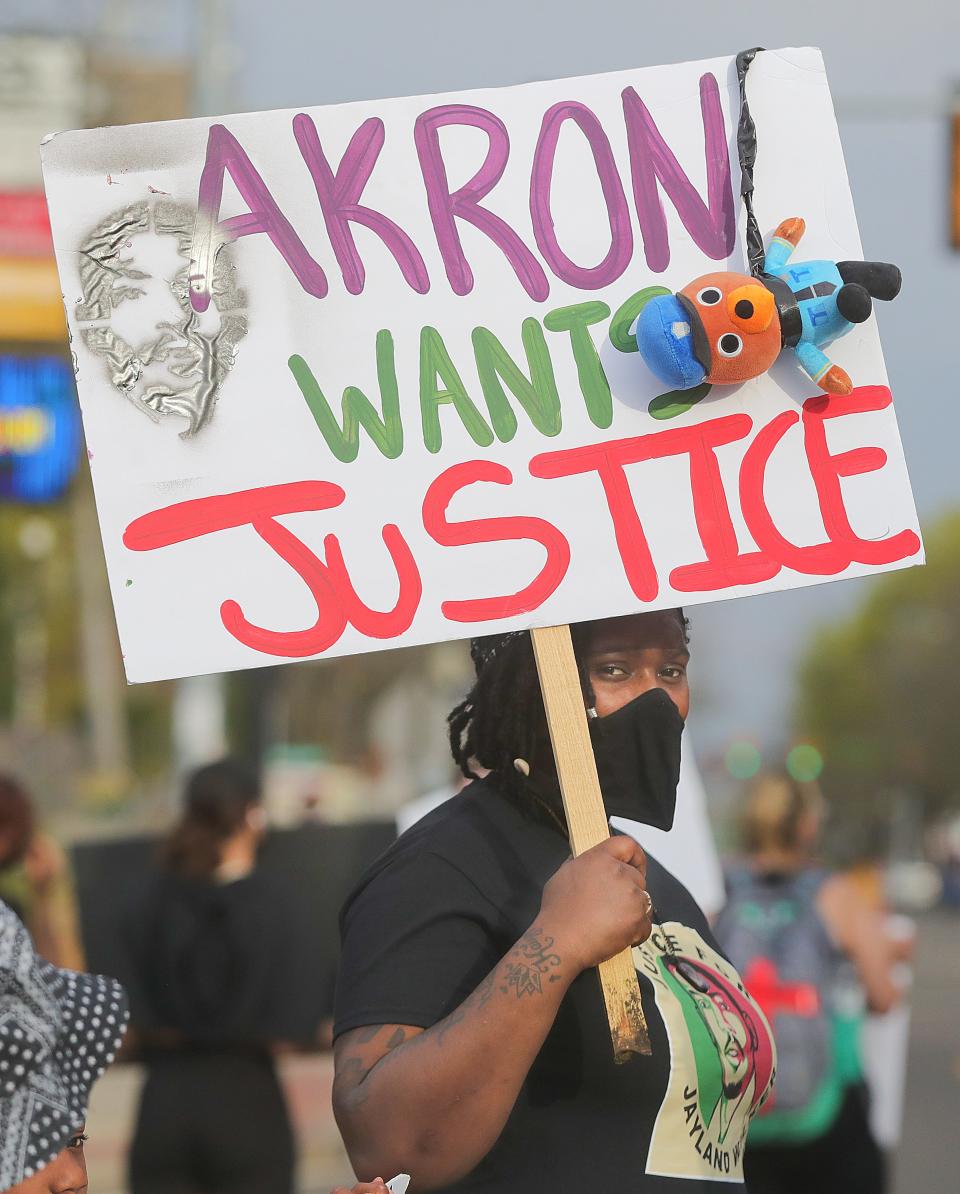 Jay Beasley holds a sign during a Justice for Jayland Walker protest in the Highland Square area of Akron on Friday.