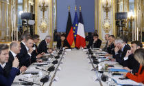 French President Emmanuel Macron, right, and German Chancellor Olaf Scholz, second left, attend a working session as part of the celebration of the 60th anniversary of the signing of the Elysee Treaty, to seal reconciliation between France and West Germany, at the Elysee Palace in Paris, Sunday, Jan.22 2023. France and Germany are seeking to overcome differences laid bare by Russia's war in Ukraine while celebrating their decades-long friendship with a day of ceremonies and talks Sunday on Europe's security, energy and other challenges. (Ludovic Marin Pool via AP)