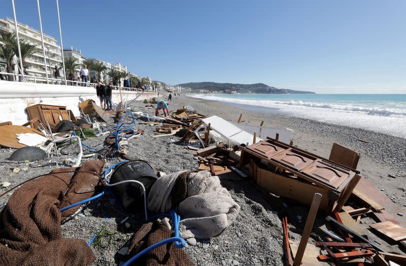 People are seen on a private beach following heavy rainfall in Nice