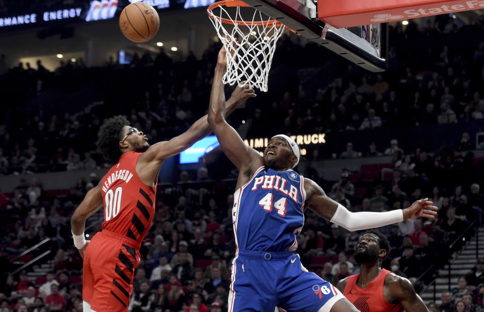 Philadelphia 76ers forward Paul Reed (44) and Portland Trail Blazers guard Scoot Henderson (00) go after a rebound during the first half of an NBA basketball game in Portland, Ore., Monday, Jan. 29, 2024. (AP Photo/Steve Dykes)