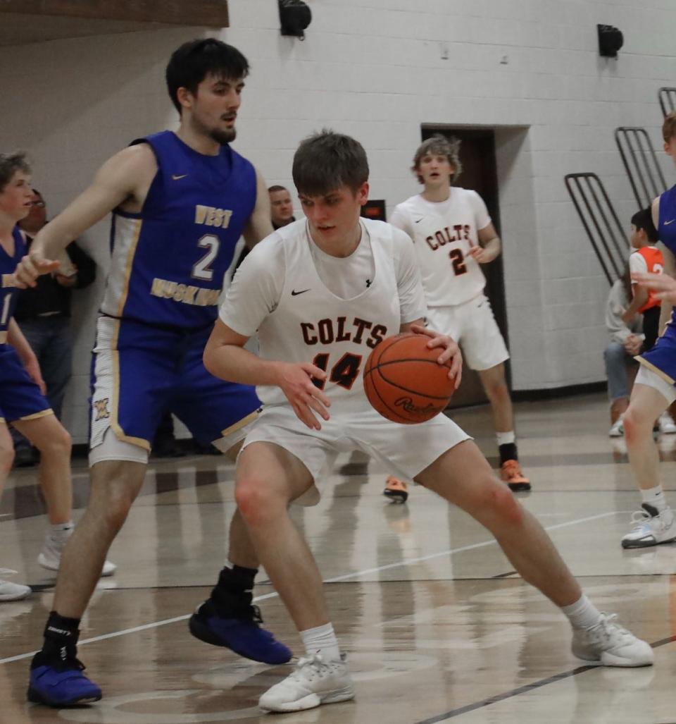 Meadowbrook senior Dayne Singleton (14) battle in the post with West Muskingum senior Noah Ray (2) during Tuesday's MVL Small School tussle in Byesville.