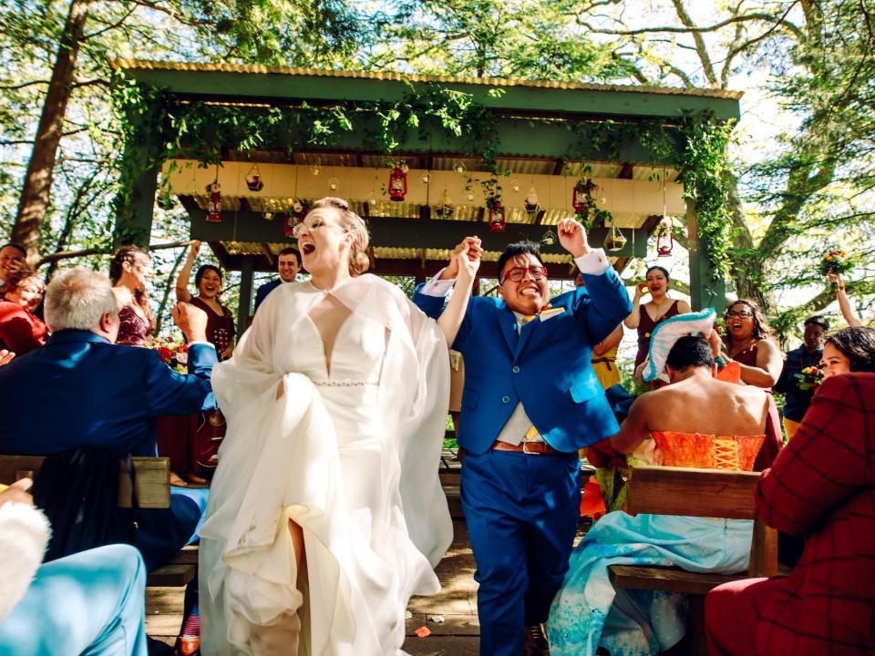 A couple celebrates as they exit their wedding ceremony.