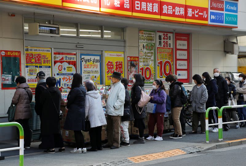 People wearing masks queue to buy masks at a drugstore in Tokyo, Japan