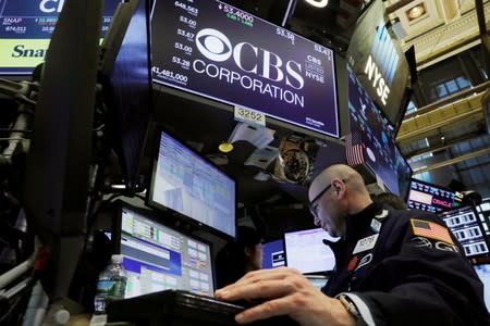 FILE PHOTO: A trader works below the CBS Corporation logo on the floor of the New York Stock Exchange shortly after the opening bell in New York