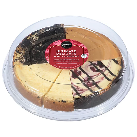 A cheesecake sampler in a clear plastic container, labeled "Ultimate Delights Variety Cheesecake" with flavors like chocolate and strawberry swirl