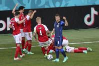 Denmark's players go to his teammate Christian Eriksen after he collapsed during the Euro 2020 soccer championship group B match between Denmark and Finland at Parken stadium in Copenhagen, Denmark, Saturday, June 12, 2021. (Wolfgang Rattay/Pool via AP)