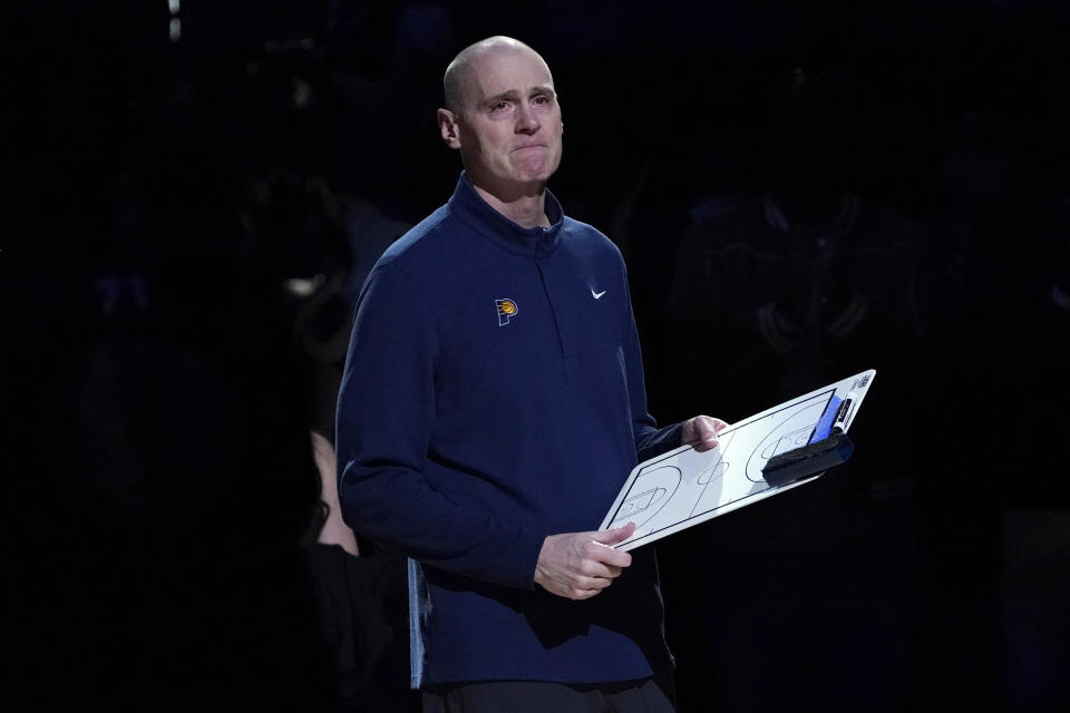 Indiana Pacers head coach Rick Carlisle fights back tears as he watches a video tribute honoring Carlisle's time in Dallas that was played on the large in-house video screen before the first half of an NBA basketball game against the Dallas Mavericks in Dallas, Saturday, Jan. 29, 2022. (AP Photo/Tony Gutierrez)