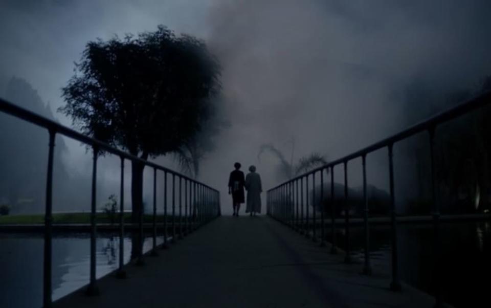 Moira and her mother walking down a misty road