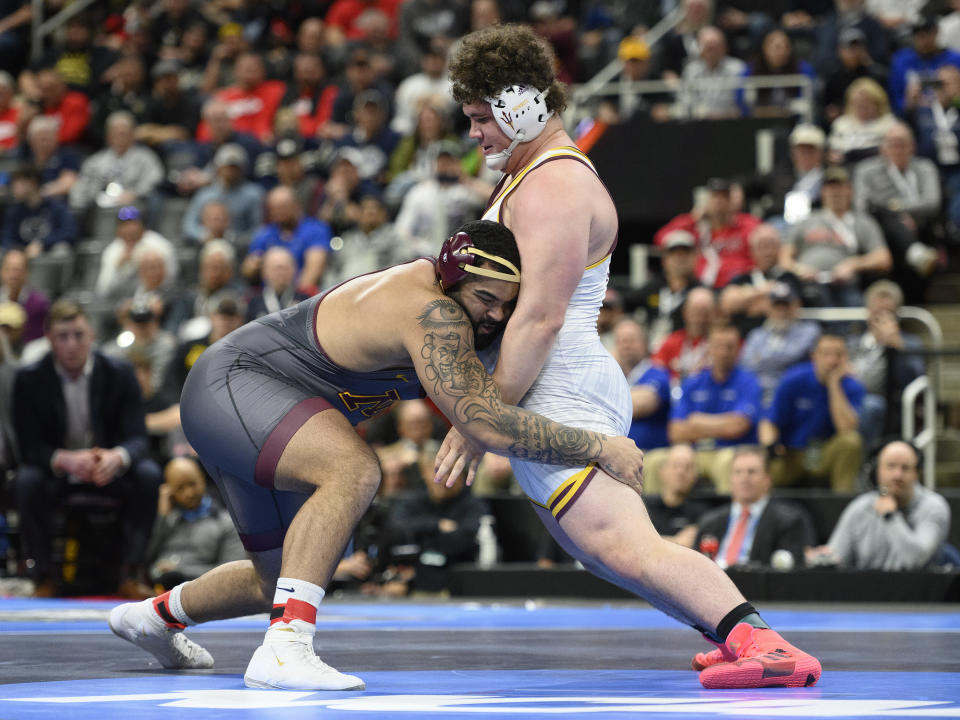 Minnesota's Gable Steveson, left, looks to take down Arizona State's Cohlton Schultz during their heavyweight match in the finals of the NCAA Division I wrestling championships in Detroit, Saturday, March 19, 2022. Steveson won the match. (Andy Morrison/Detroit News via AP)