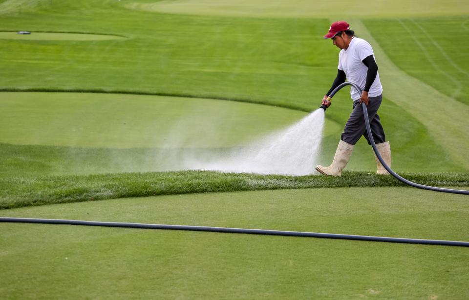 Groundskeeper Roberto Garcia waters down hot spots around a tee during the Honda Classic practice rounds at PGA National in Palm Beach Gardens on February 20, 2018.  (Richard Graulich / The Palm Beach Post)