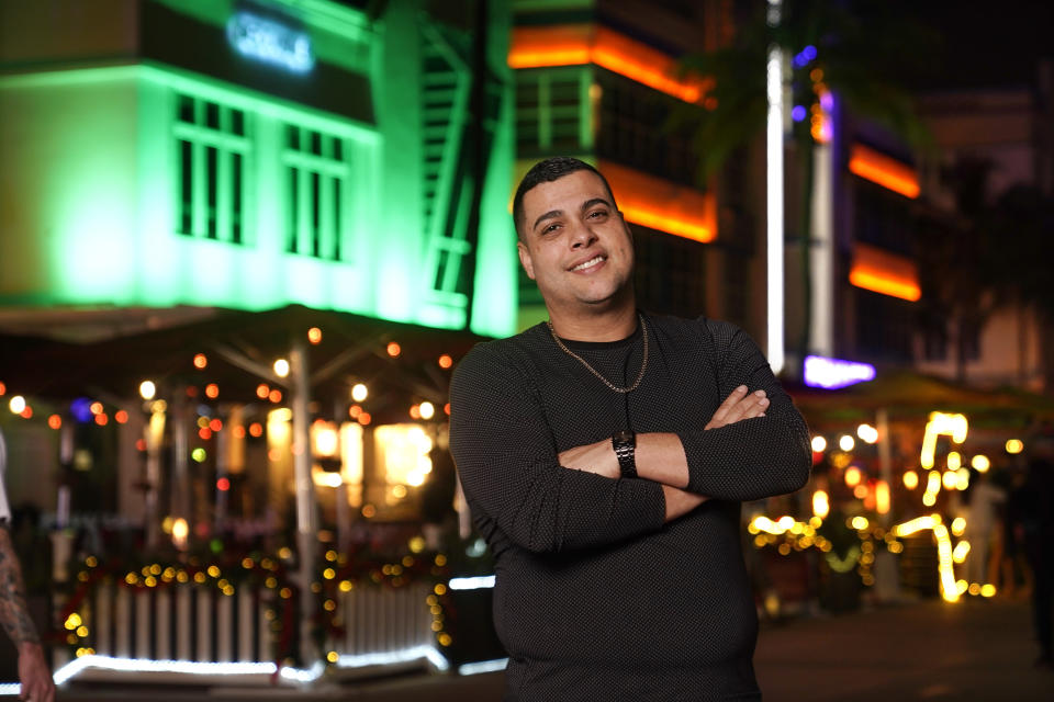 Frank Ayllon poses in Miami Beach, Fla., Dec. 10, 2020. Ayllon, a 37-year-old food services consultant in Miami, credits Trump with dispelling political correctness, with bringing jobs back from overseas and regaining international respect for America. (AP Photo/Mark Humphrey)