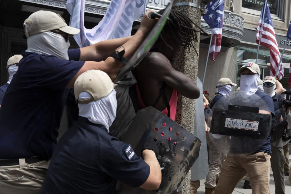 FILE - Members of a group bearing insignias of the white supremacist Patriot Front shove Charles Murrell with metal shields during a march through Boston on July 2, 2022. The Black musician who says members of the white nationalist hate group punched, kicked and beat him with metal shields during a march through Boston in 2022 sued the organization on Tuesday, Aug. 8, 2023. (AP Photo/Michael Dwyer, File)