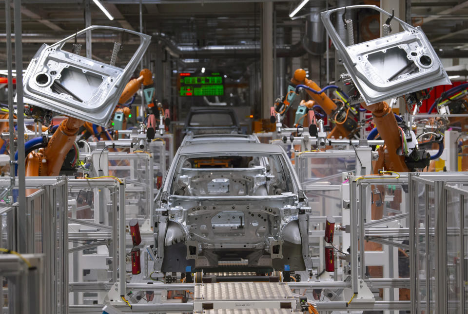 FILE- In this Tuesday, Feb. 25, 2020 file photo, robots work on an electric car ID.3 body at the assembly line during a press tour at the plant of the German manufacturer Volkswagen AG (VW) in Zwickau, Germany. The coronavirus has cancelled business plans all over the world but Europe's push into electric cars isn't one of them. Sales of battery-powered and hybrid cars have held up despite a deeply painful recession, mainly thanks to the action of governments. (AP Photo/Jens Meyer, file)