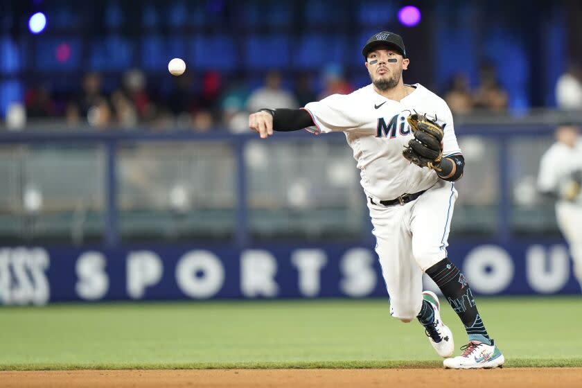 Miami Marlins shortstop Miguel Rojas throws to first where Washington Nationals' Lane Thomas was out during the seventh inning of a baseball game, Sunday, Sept. 25, 2022, in Miami. The Nationals won 6-1. (AP Photo/Lynne Sladky)