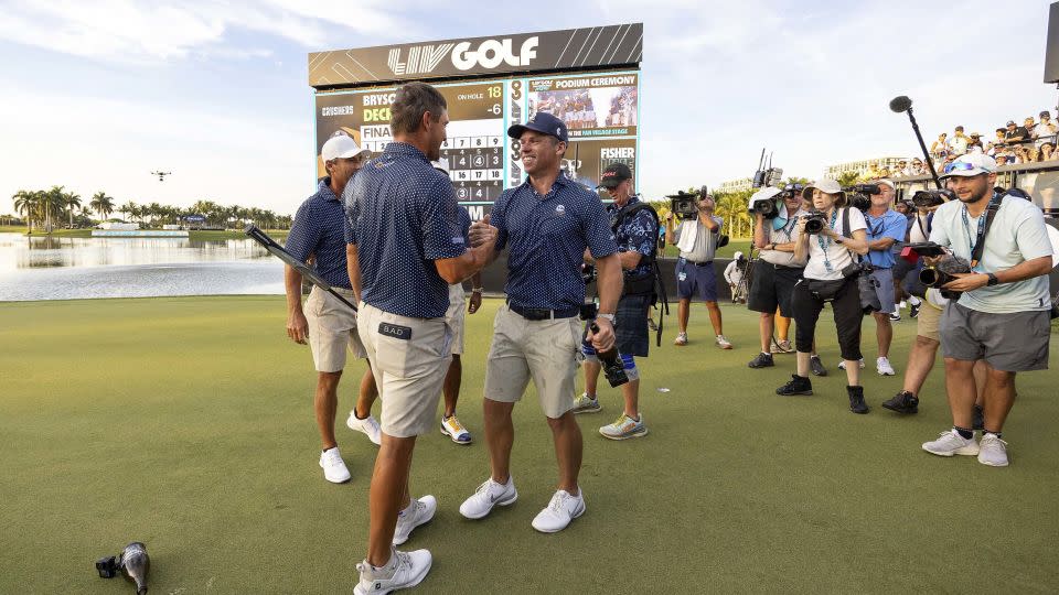 Bryson DeChambeau and Paul Casey of Crushers GC shake hands as they celebrate with teammate Charles Howell III and Anirban Lahiri on the 18th green after the finals of the LIV Golf Team Championship Miami, October 22, 2023. - Chris Trotman/LIV Golf/AP