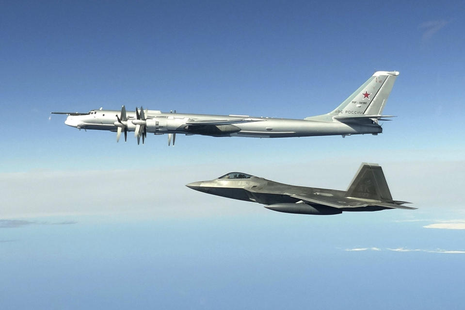 FILE - In this June 16, 2020, image released by the North American Aerospace Defense Command, a Russian Tu-95 bomber, top, is intercepted by a U.S. F-22 Raptor fighter off the coast of Alaska. The Air National Guard has delayed personnel changes in Alaska until Sept. 2025, that could have threatened national security and civilian rescue missions. (North American Aerospace Defense Command via AP)