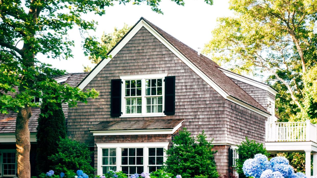 a house with a large collection of hydrangeas in front