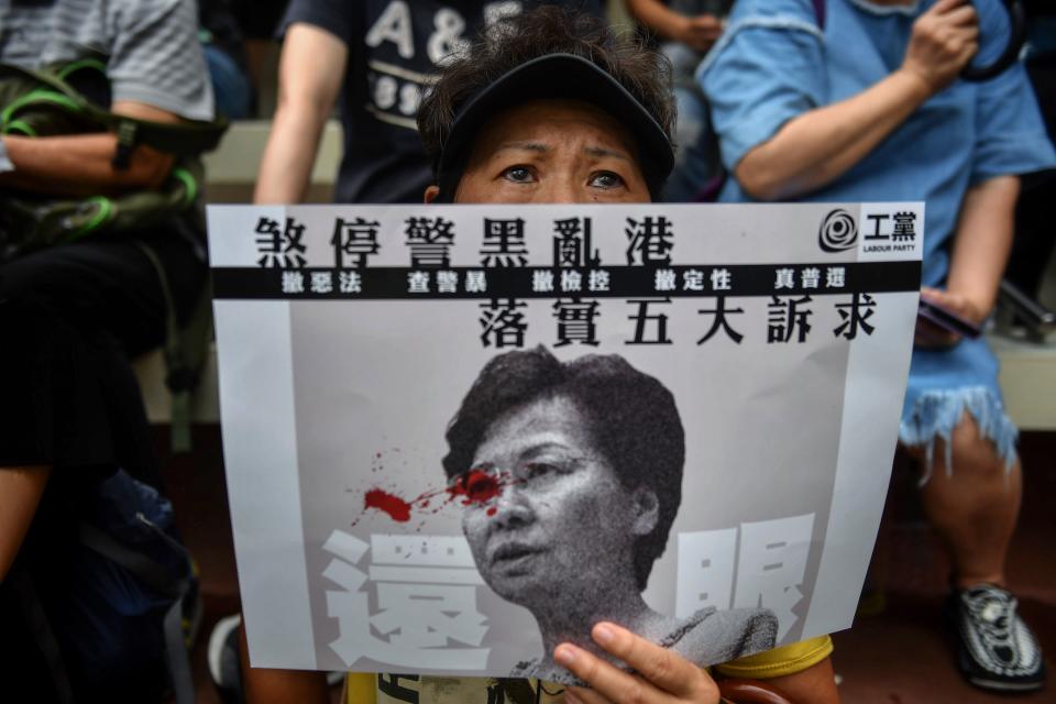 A woman displays a poster bearing an image of Hong Kong Chief Executive Carrie Lam during a protest at Southorn Playground in Hong Kong on August 31, 2019. - Thousands of pro-democracy protesters defied a police ban on rallying in Hong Kong on August 31, a day after several leading activists and lawmakers were arrested in a sweeping crackdown. (Photo by Lillian SUWANRUMPHA / AFP)        (Photo credit should read LILLIAN SUWANRUMPHA/AFP/Getty Images)