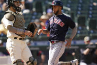 Cleveland Indians' Eddie Rosario, right, scores as Seattle Mariners catcher Luis Torrens looks on in the sixth inning of a baseball game Sunday, May 16, 2021, in Seattle. (AP Photo/Elaine Thompson)