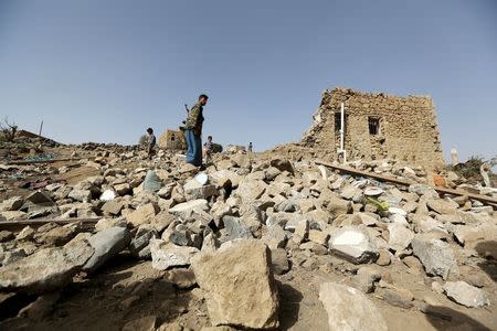 A man walks on the rubble of a house destroyed by an air strike in the Bait Rejal village west of Yemen's capital Sanaa April 7, 2015. REUTERS/Khaled Abdullah