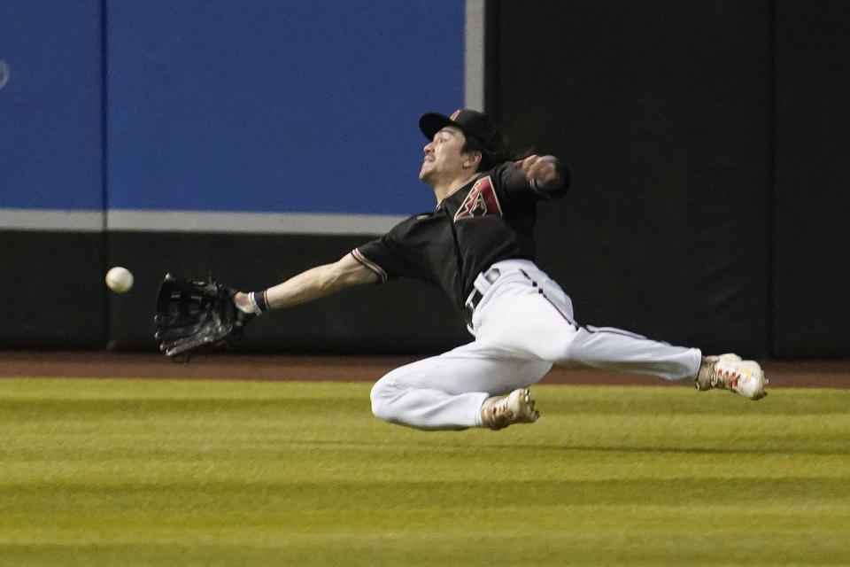 Arizona Diamondbacks center fielder Corbin Carroll makes a diving catch of a ball hit by Atlanta Braves' Michael Harris II during the third inning of a baseball game Saturday, June 3, 2023, in Phoenix. (AP Photo/Darryl Webb)