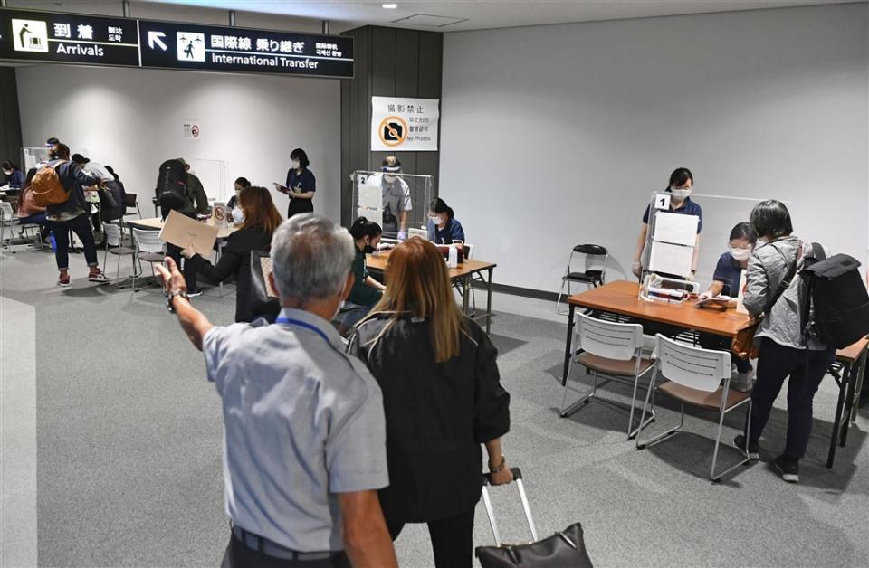 ▲日本1日宣布停售所有國際線飛抵日本的機位，但政策2日卻急轉彎。圖為外籍人士10月抵達日本成田機場。（圖／翻攝自共同社）