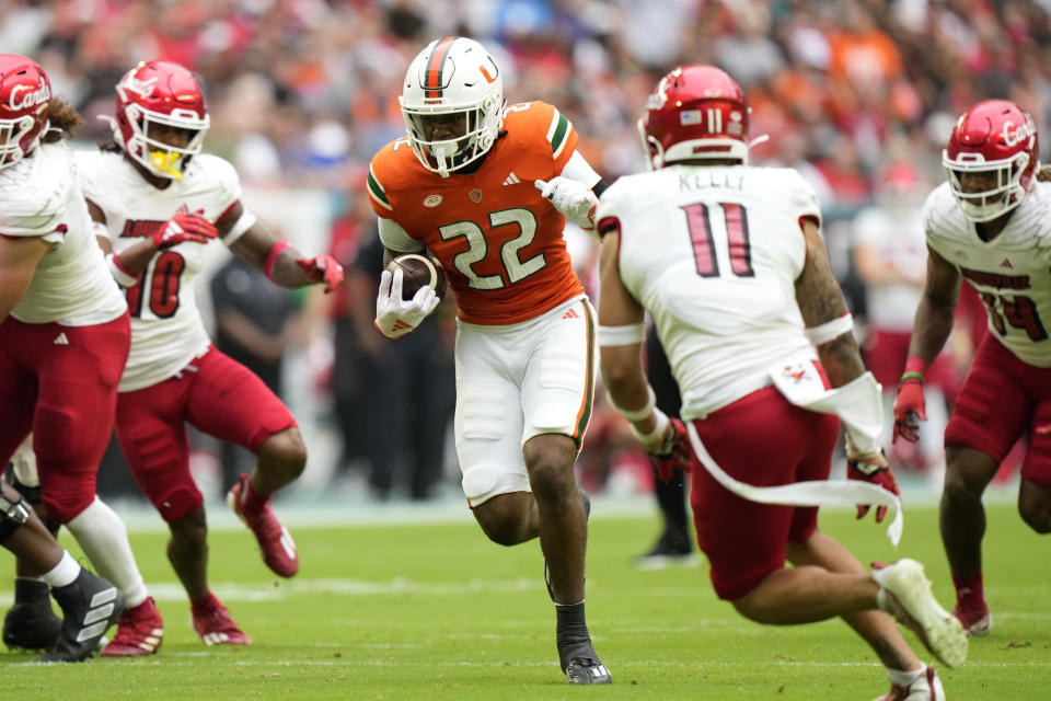 Miami running back Mark Fletcher Jr. (22) runs for yardage during the first half of an NCAA college football game against Louisville, Saturday, Nov. 18, 2023, in Miami Gardens, Fla. (AP Photo/Wilfredo Lee)