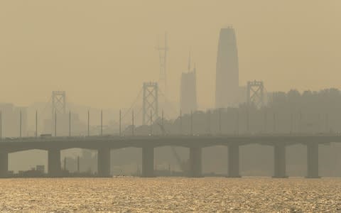 Smoke and haze obscure the Bay Bridge and San Francisco skyline - Credit: AP