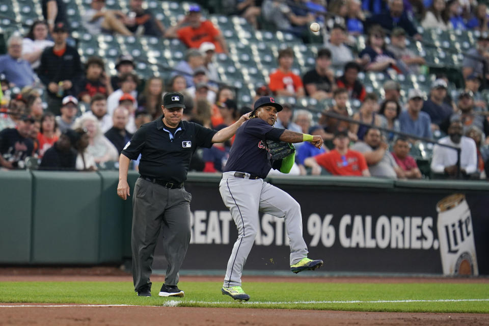 Third base umpire Doug Eddings, left, gestures as Cleveland Guardians third baseman Jose Ramirez makes an off balance throw on an infield single by Baltimore Orioles' Ryan Mountcastle during the third inning of a baseball game, Tuesday, May 30, 2023, in Baltimore. (AP Photo/Julio Cortez)