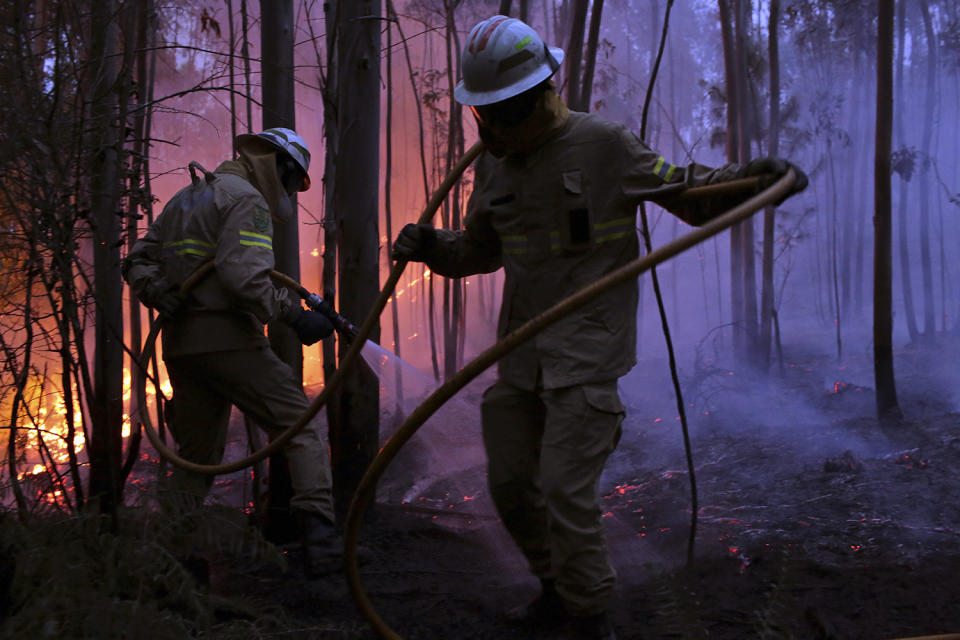 Firefighters spraying water onto fire