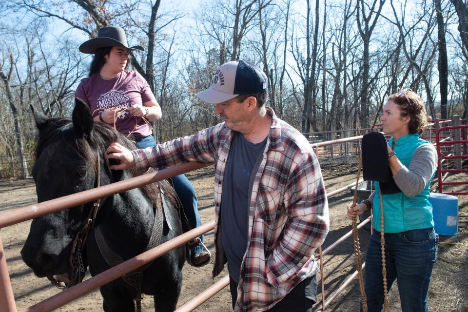 Tony and Kristina Saliceti on Friday support their daughter Angeline while she gives Samson, a black stallion they helped raise into a champion.