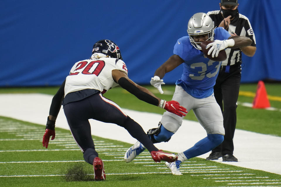 Detroit Lions running back Kerryon Johnson (33) runs out of bounds as Houston Texans strong safety Justin Reid (20) defends during the first half of an NFL football game, Thursday, Nov. 26, 2020, in Detroit. (AP Photo/Paul Sancya)