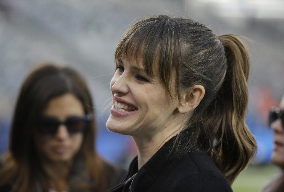 Actress Jennifer Garner smiles as she stands on the field at MetLife Stadium before the NFL Super Bowl XLVIII football game between the Seattle Seahawks and the Denver Broncos Sunday, Feb. 2, 2014, in East Rutherford, N.J. (AP Photo/Matt Slocum)