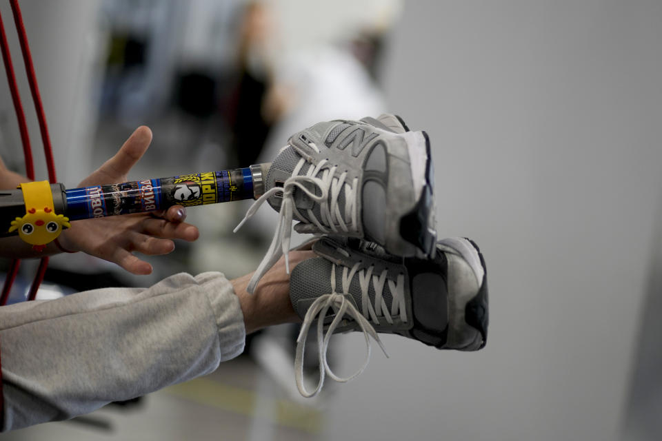 A doctor helps "Buffalo" train his new prosthetic limb at a clinic in Kyiv, Ukraine, Friday, June 17, 2022. "Buffalo" has a small yellow plastic bird attached to his new prosthetic limb because, "I have to be a serious man at work, but in my heart, I am a child." (AP Photo/Natacha Pisarenko)
