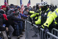 Trump supporters try to break through a police barrier, Wednesday, Jan. 6, 2021, at the Capitol in Washington. (AP Photo/John Minchillo)